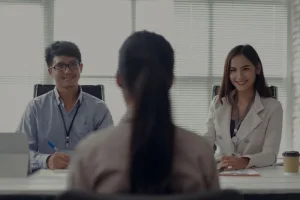 A-person-and-person-sitting-at-a-table-in-front-of-a-laptop