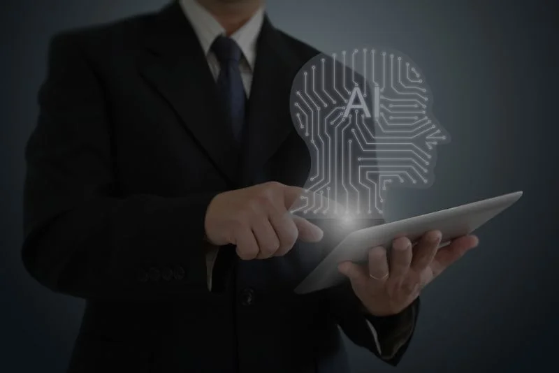 a-person-in-a-suit-holding-a-tablet-computer-with-an-image-of-a-head-on-it