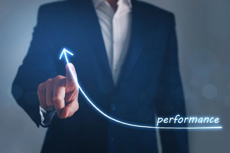 a person in a suit is pointing to the word performance